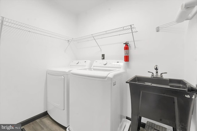 washroom featuring sink, separate washer and dryer, and hardwood / wood-style floors