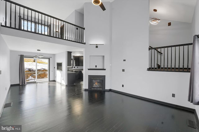 unfurnished living room with a high ceiling and wood-type flooring