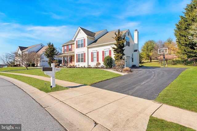 traditional-style house with driveway and a front yard