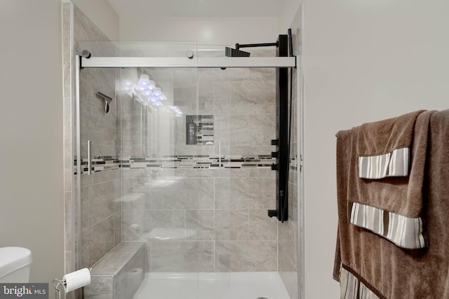 full bath featuring toilet and a shower stall