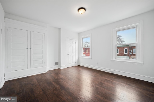 unfurnished bedroom with dark hardwood / wood-style floors