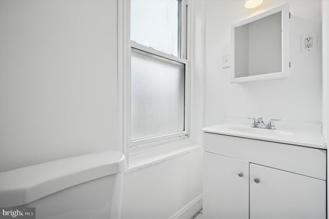 bathroom with plenty of natural light, vanity, and toilet