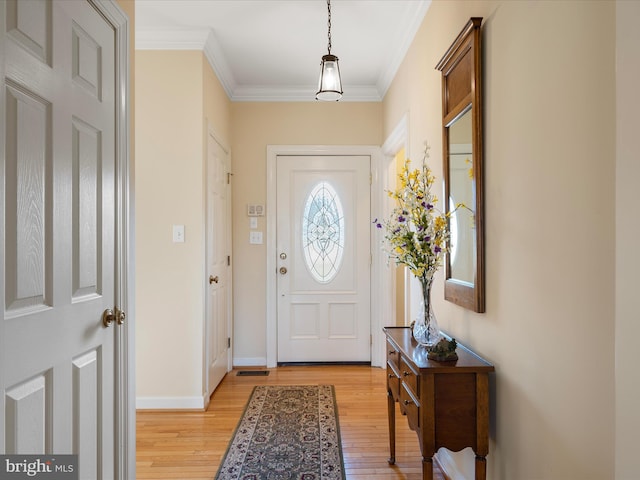 entrance foyer with light wood-type flooring, crown molding, and baseboards