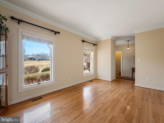 unfurnished room featuring baseboards, light wood-type flooring, visible vents, and crown molding