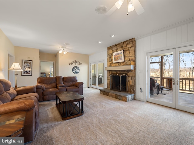 living room with ceiling fan, a fireplace, light colored carpet, and french doors