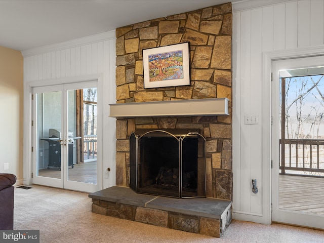 room details with carpet, french doors, and a stone fireplace