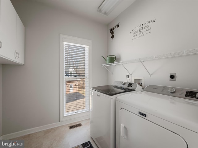 clothes washing area featuring visible vents, washing machine and clothes dryer, cabinet space, and baseboards