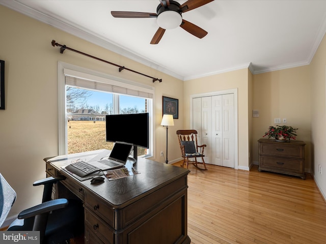 home office featuring ornamental molding, light wood-type flooring, baseboards, and a ceiling fan