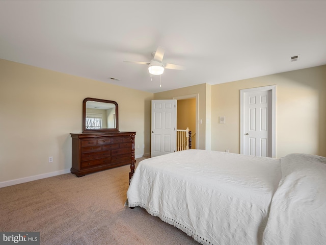 carpeted bedroom with a ceiling fan, visible vents, and baseboards