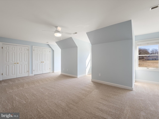 bonus room featuring ceiling fan, baseboards, visible vents, and light colored carpet