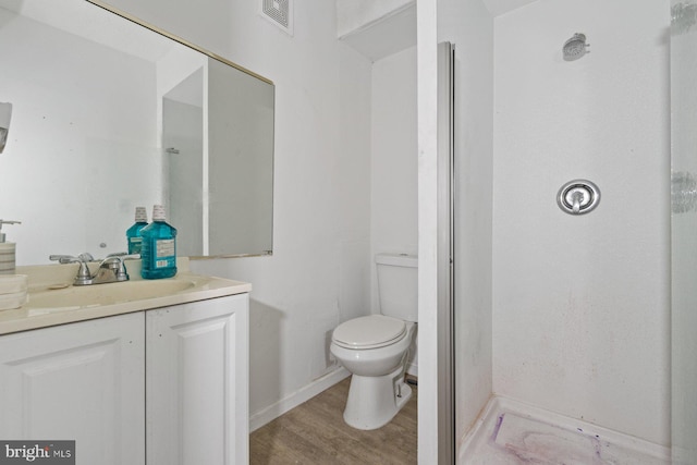 bathroom with toilet, wood-type flooring, and vanity