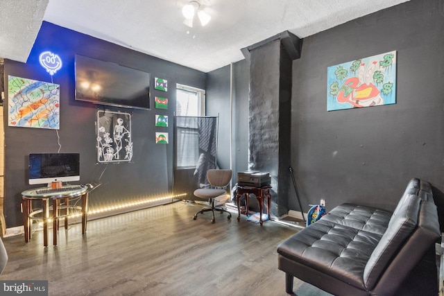 sitting room with hardwood / wood-style floors and a textured ceiling