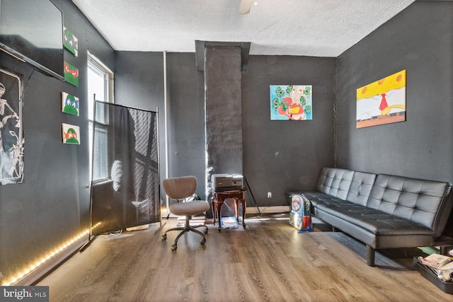 sitting room with a textured ceiling and wood-type flooring