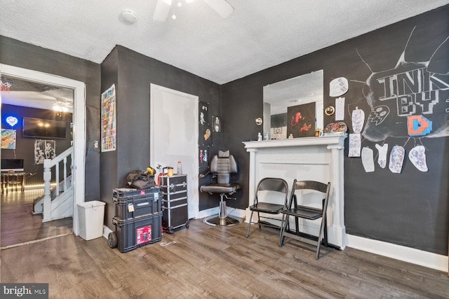 interior space with a textured ceiling, ceiling fan, and wood-type flooring