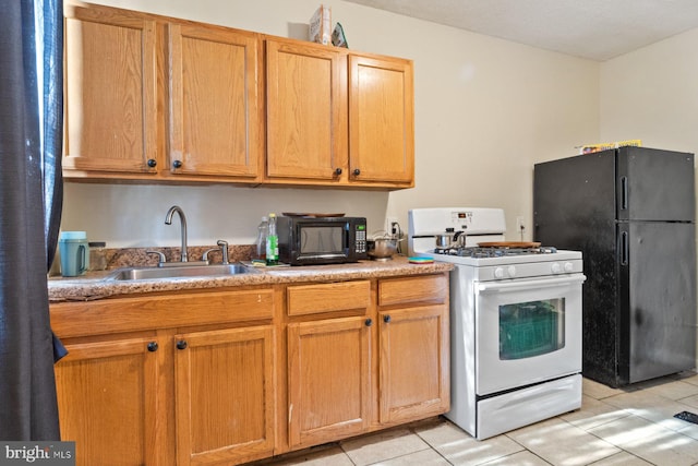 kitchen with light tile patterned flooring, sink, and black appliances