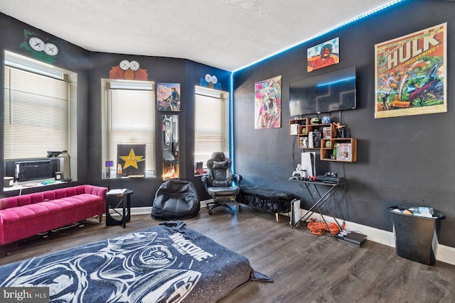 bedroom featuring cooling unit, hardwood / wood-style flooring, and a textured ceiling