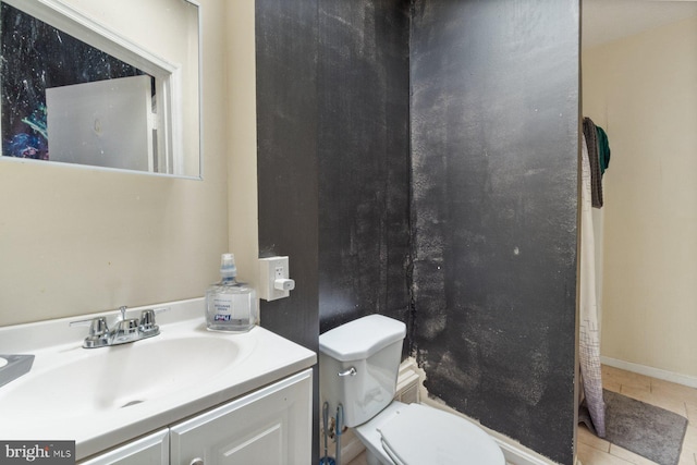 bathroom featuring toilet, vanity, and tile patterned flooring