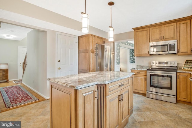 kitchen featuring baseboards, a kitchen island, decorative light fixtures, light stone countertops, and stainless steel appliances