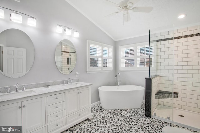 bathroom with vaulted ceiling, tile patterned flooring, a sink, and a shower stall