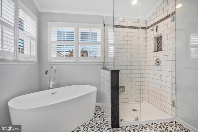 bathroom featuring a freestanding tub, tile patterned floors, ornamental molding, and a stall shower