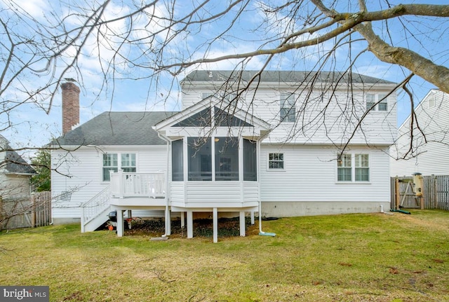 back of property featuring a lawn, stairway, a chimney, and a sunroom