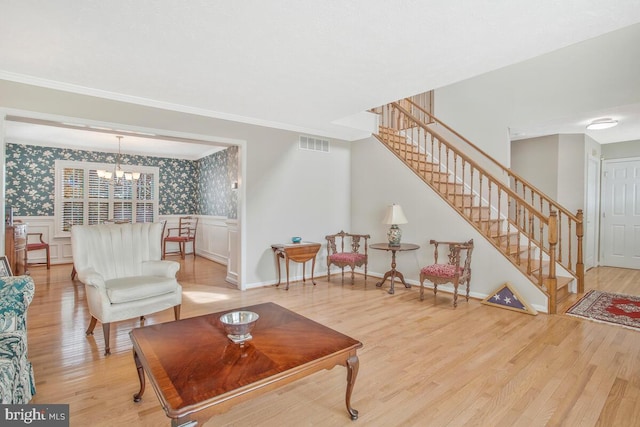 living room with light wood-type flooring, wallpapered walls, stairs, and visible vents