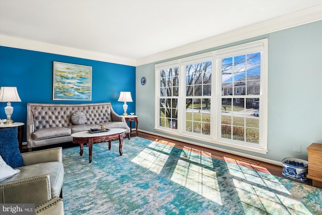 living room featuring ornamental molding, wood finished floors, visible vents, and baseboards