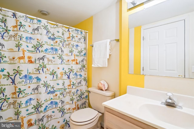 full bathroom featuring a shower with shower curtain, vanity, and toilet