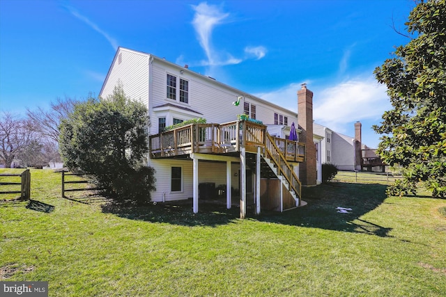 back of property featuring stairs, a lawn, a deck, and fence