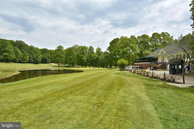 view of property's community with a water view and a lawn