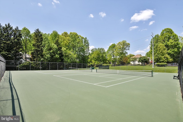 view of tennis court with community basketball court and fence