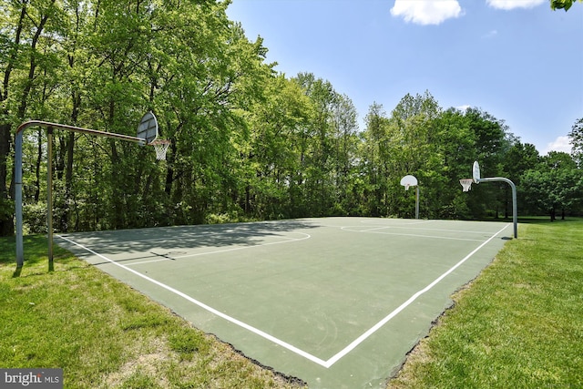 view of basketball court with community basketball court and a lawn