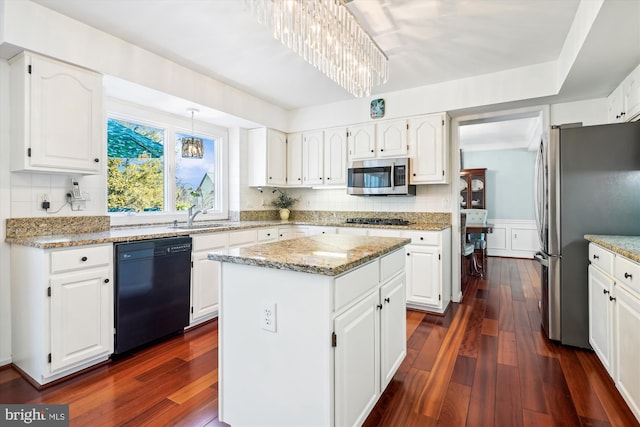 kitchen with dark wood-style floors, tasteful backsplash, a kitchen island, light stone countertops, and black appliances