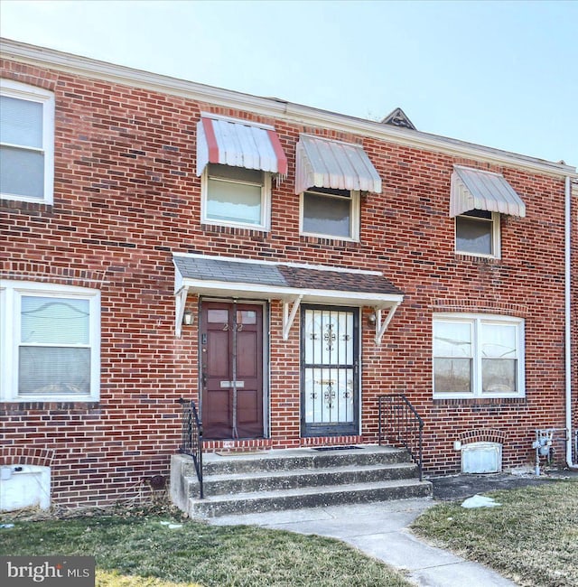 townhome / multi-family property with entry steps and brick siding