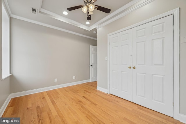 unfurnished bedroom with crown molding, light wood-style flooring, and baseboards