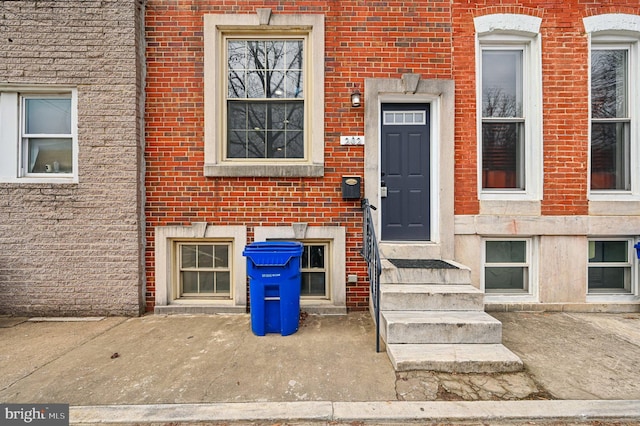 entrance to property featuring brick siding