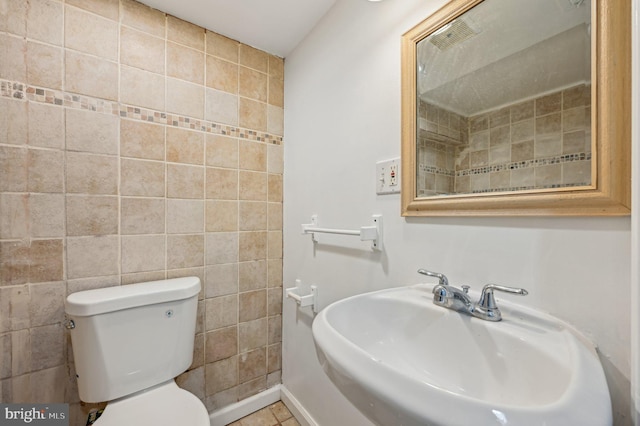 bathroom featuring a sink, toilet, and tile patterned floors