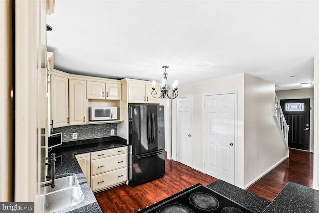 kitchen featuring a notable chandelier, cream cabinetry, dark hardwood / wood-style floors, black appliances, and hanging light fixtures