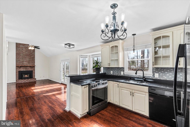 kitchen with sink, black dishwasher, stainless steel range with electric stovetop, cream cabinetry, and decorative light fixtures