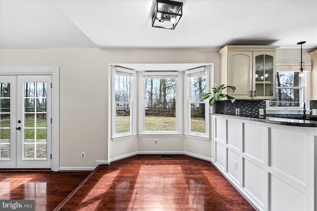 unfurnished dining area with dark hardwood / wood-style flooring, french doors, and a wealth of natural light