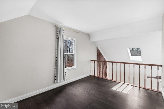 bonus room featuring dark hardwood / wood-style flooring and vaulted ceiling with skylight