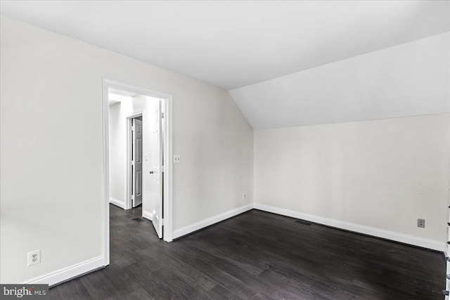 additional living space with dark wood-type flooring and lofted ceiling