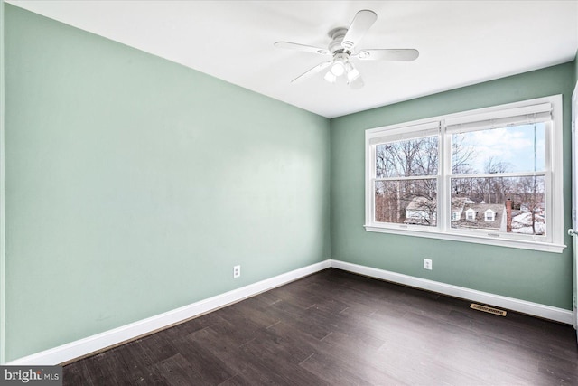 empty room with ceiling fan and dark hardwood / wood-style flooring