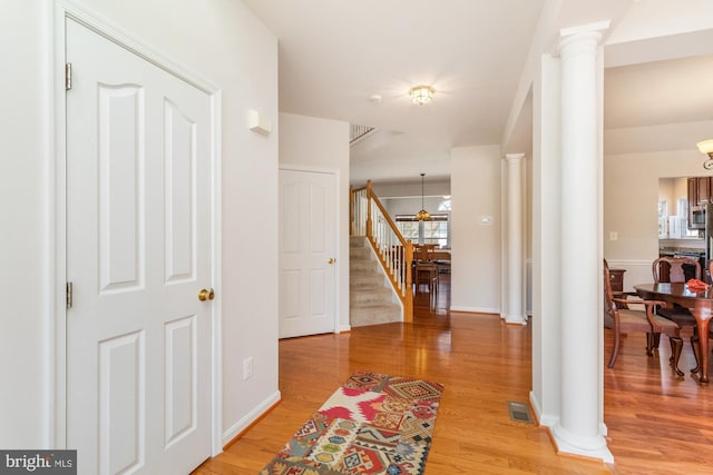 entryway featuring ornate columns and light hardwood / wood-style floors