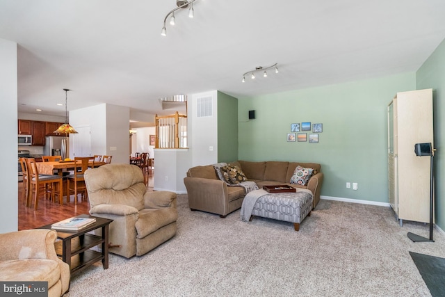 living room featuring rail lighting and light colored carpet