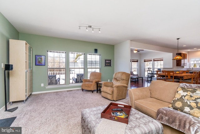 carpeted living room featuring ceiling fan