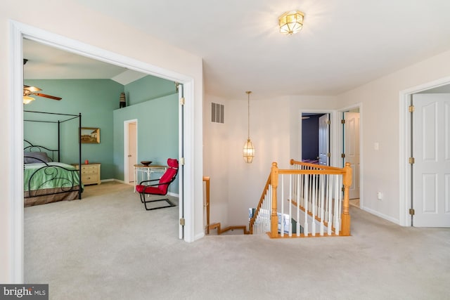 corridor with light carpet and lofted ceiling