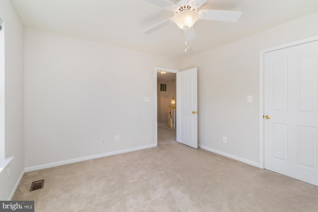 unfurnished bedroom with ceiling fan and light colored carpet