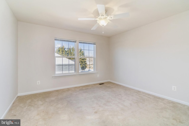 carpeted spare room featuring ceiling fan