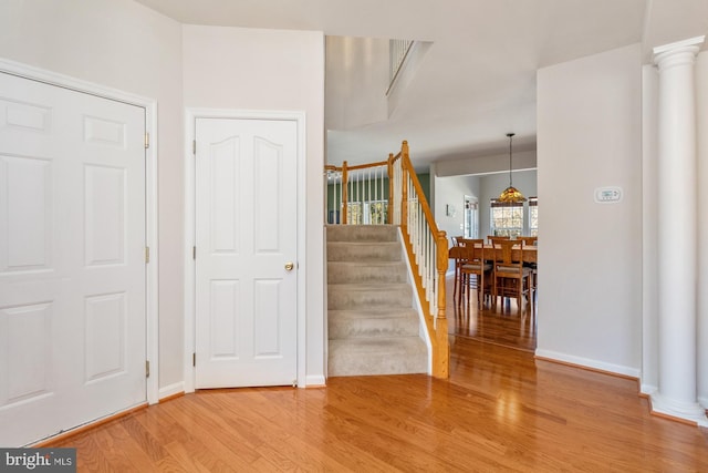 stairway featuring ornate columns and hardwood / wood-style flooring